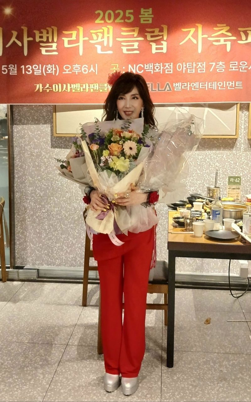 가수 이사벨라가 축하 꽃다발을 받고 포즈를 취하고 있다.