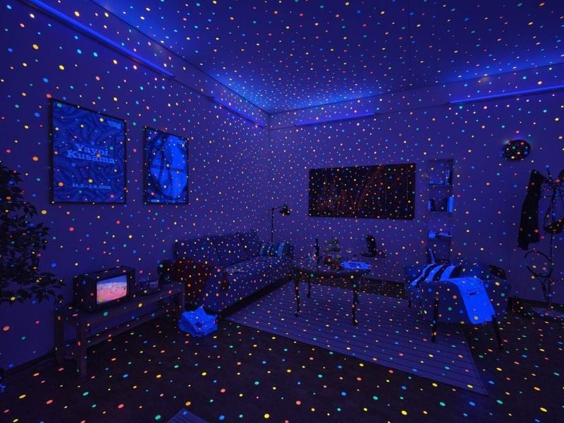 다채로운 빛의 점들이 투사된 푸른 조명 아래 거실의 사진입니다